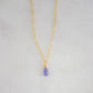 An image of a smooth polished natural, real tanzanite gemstone teardrop suspended from a 14k gold filled chain. Also available in sterling silver. Handmade in Connecticut by Gemnia.