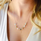 Modeled image of a sterling silver style. A multi-color burma jade necklace featuring seven round green, brown, yellow, or blue natural stones. Handmade in Connecticut by Gemnia Jewelry.
