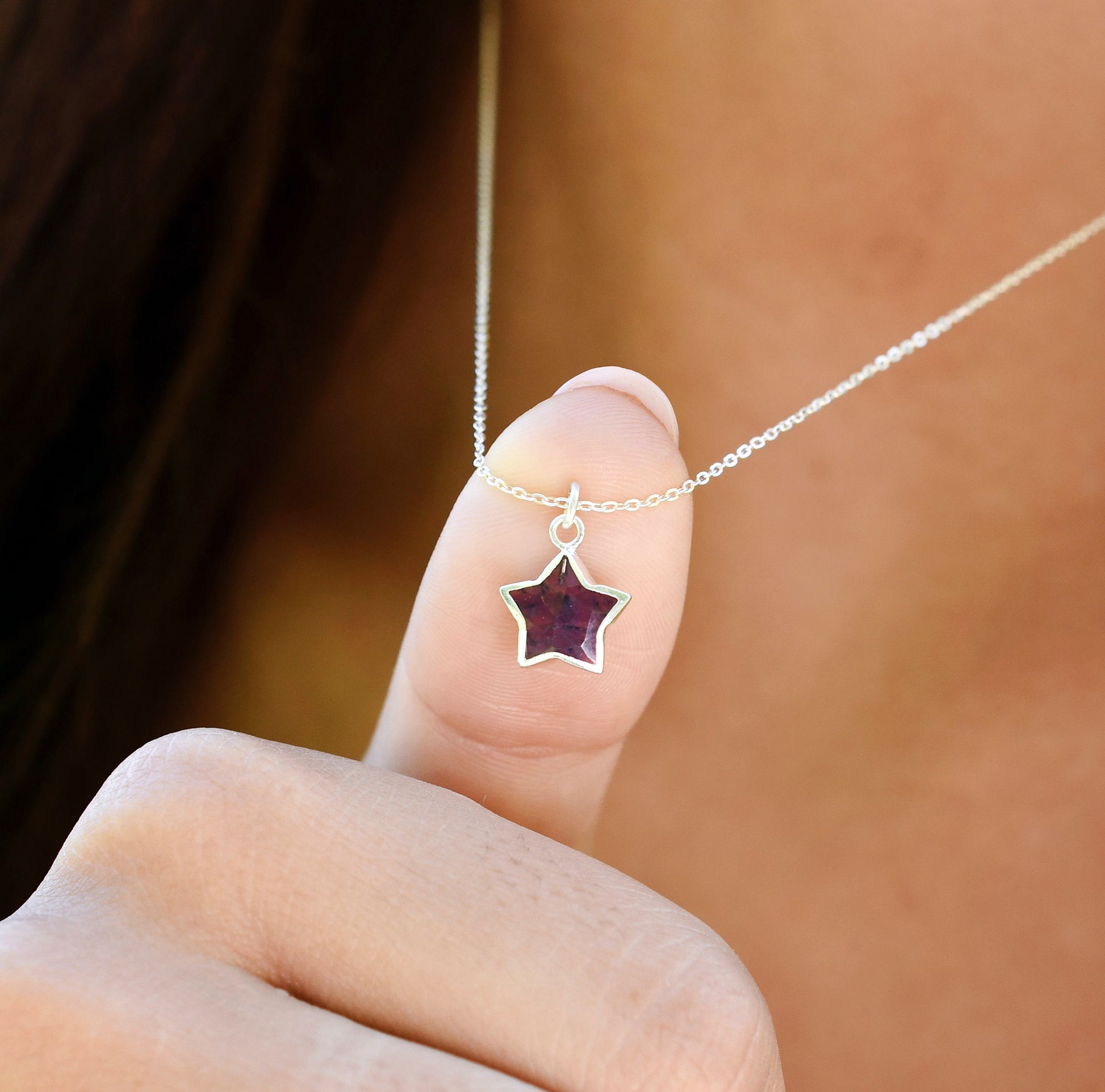 Star-shaped pendant necklace modeled in sterling silver. The gemstone is a natural purple amethyst.