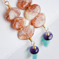 Three sunstone gemstone dangle atop amethyst and amazonite stones. The earring are shown in gold. Close up of the crystals.
