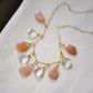 Orange, peach Sunstone and clear Crystal Quartz teardrops dangle off a 14k gold filled chain. 