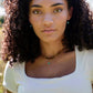 A woman wearing two layered necklaces of beaded tiger eye gemstones and natural blue turquoise drop pendant on 14k gold filled chain. Handmade in New England by Gemnia.
