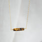 Tiger Eye gemstone necklace. A smooth polished Tiger Eye stone in a bar or tube shape set onto a 14k gold filled chain.