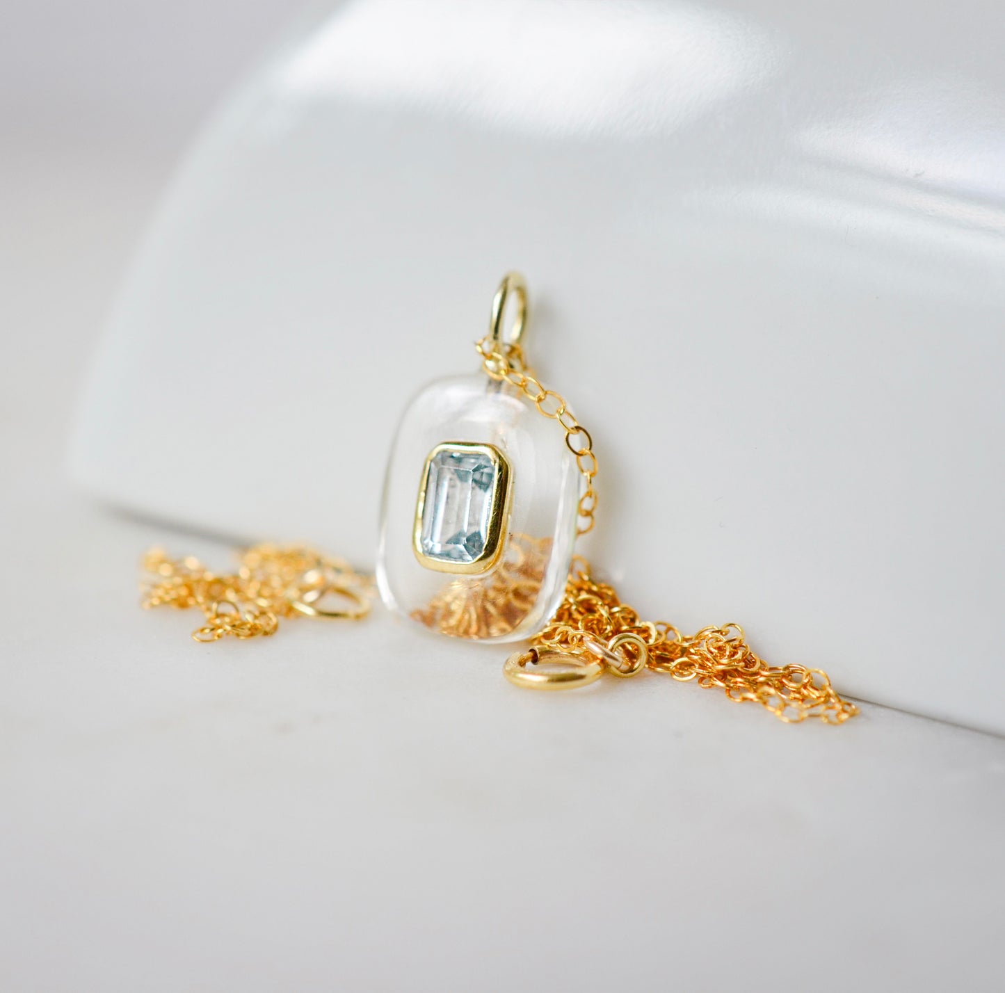 Handmade Maris necklace featuring a Blue Topaz set inside a clear Rock Crystal frame on a 14K Gold Filled chain. Ideal gift for wife, girlfriend, or mom. Minimalist topaz pendant for layering. Also a November birthstone.