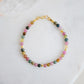 Multi color natural tourmaline stones on a beaded bracelet. Shown in gold.