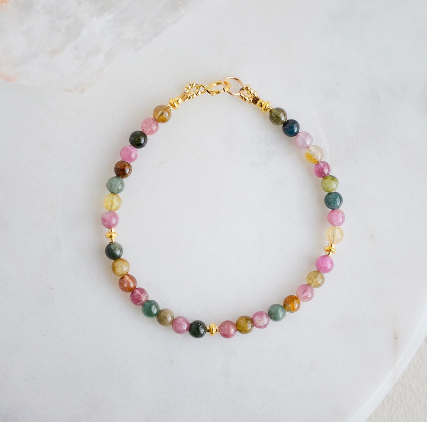 Multi color natural tourmaline stones on a beaded bracelet. Shown in gold.