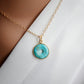 A turquoise donut-shaped pendant necklace with a gold-filled chain.