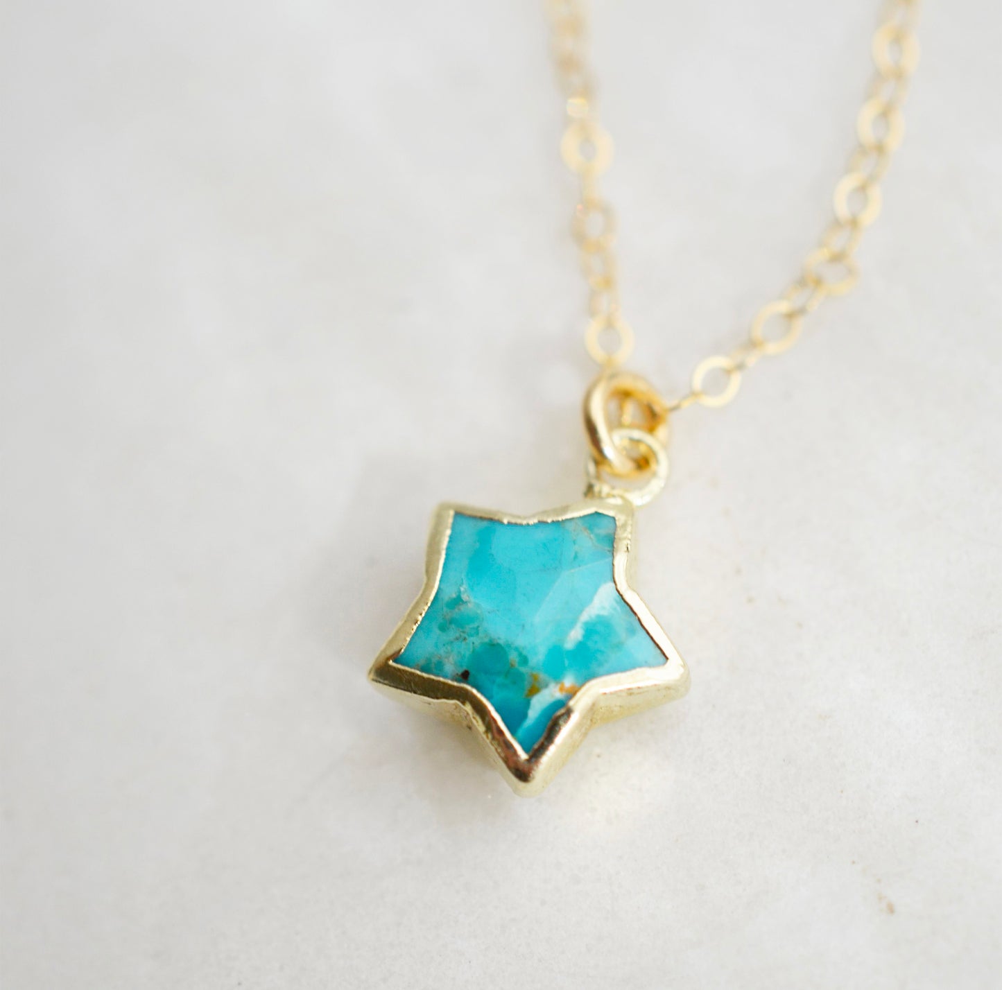 Natural blue turquoise star pendant on a 14k gold filled chain. Close up image.