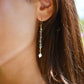 Modeled image of a woman wearing beaded labradorite and freshwater pearl long dangle earrings. The dainty minimalist style is handmade by Gemnia in Connecticut.