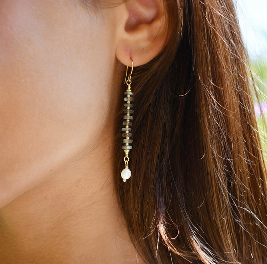 Modeled image of a woman wearing beaded labradorite and freshwater pearl long dangle earrings. The dainty minimalist style is handmade by Gemnia in Connecticut.