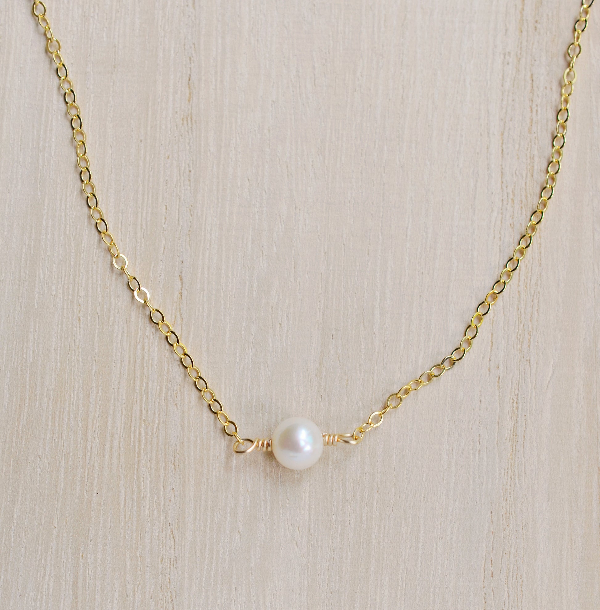 Single round white freshwater pearl necklace on a 14k gold filled chain.