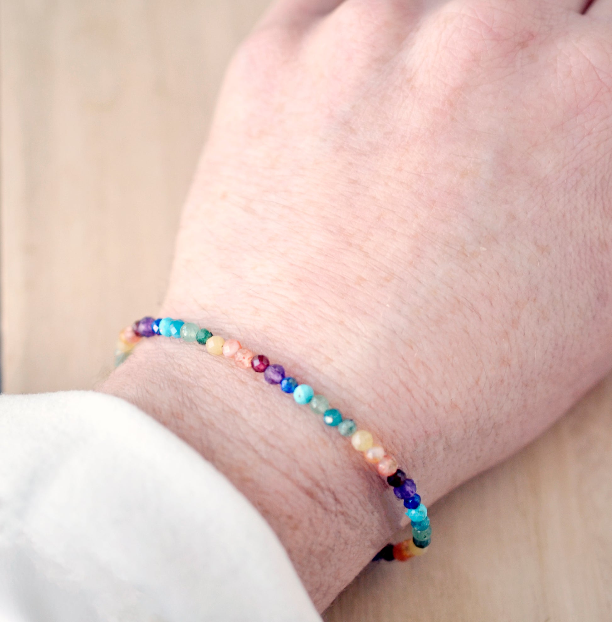 A handmade, beaded, multi-color gemstone bracelet depicting the rainbow, pride, or the chakras. Natural crystals include: turquoise, apatite, emerald, garnet, yellow opal, amethyst, aventurine, and lapis lazuli. Handcrafted in Connecticut by Gemnia Jewelry.