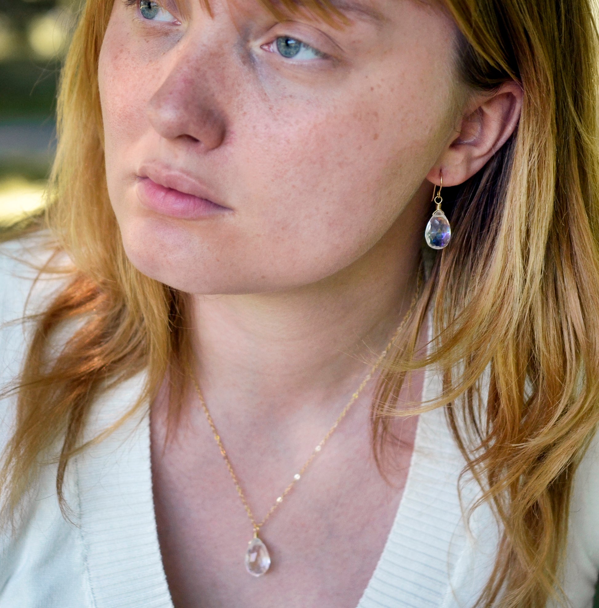 Rainbow Mystic Topaz dangle earrings. The stones are teardrop shaped. Modeled with matching necklace.