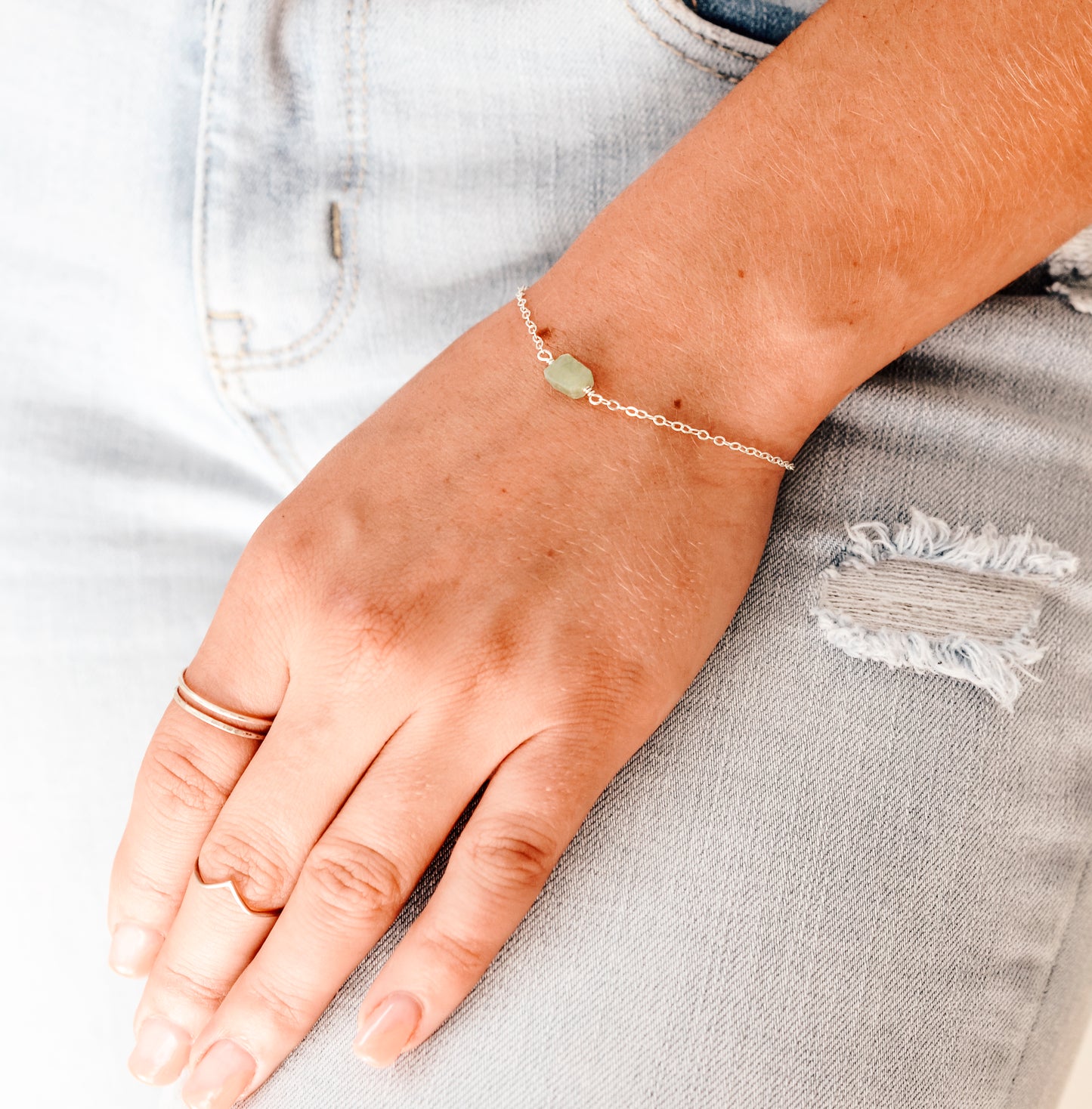 Pale green raw jade stone set onto a 14k gold filled chain.  Modeled image.