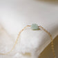 Pale green raw jade stone set onto a 14k gold filled chain. 